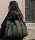 Une femme portant un sac de voyage kaki